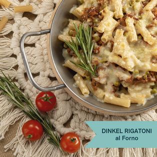 Dinkel-Rigatoni al Forno mit cremiger Sauce, Rosmarin und Kirschtomaten auf einem rustikalen Holzbrett