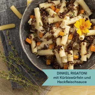 Dinkel Rigatoni mit Kürbiswürfeln und Hackfleischsoße in einer grauen Schüssel