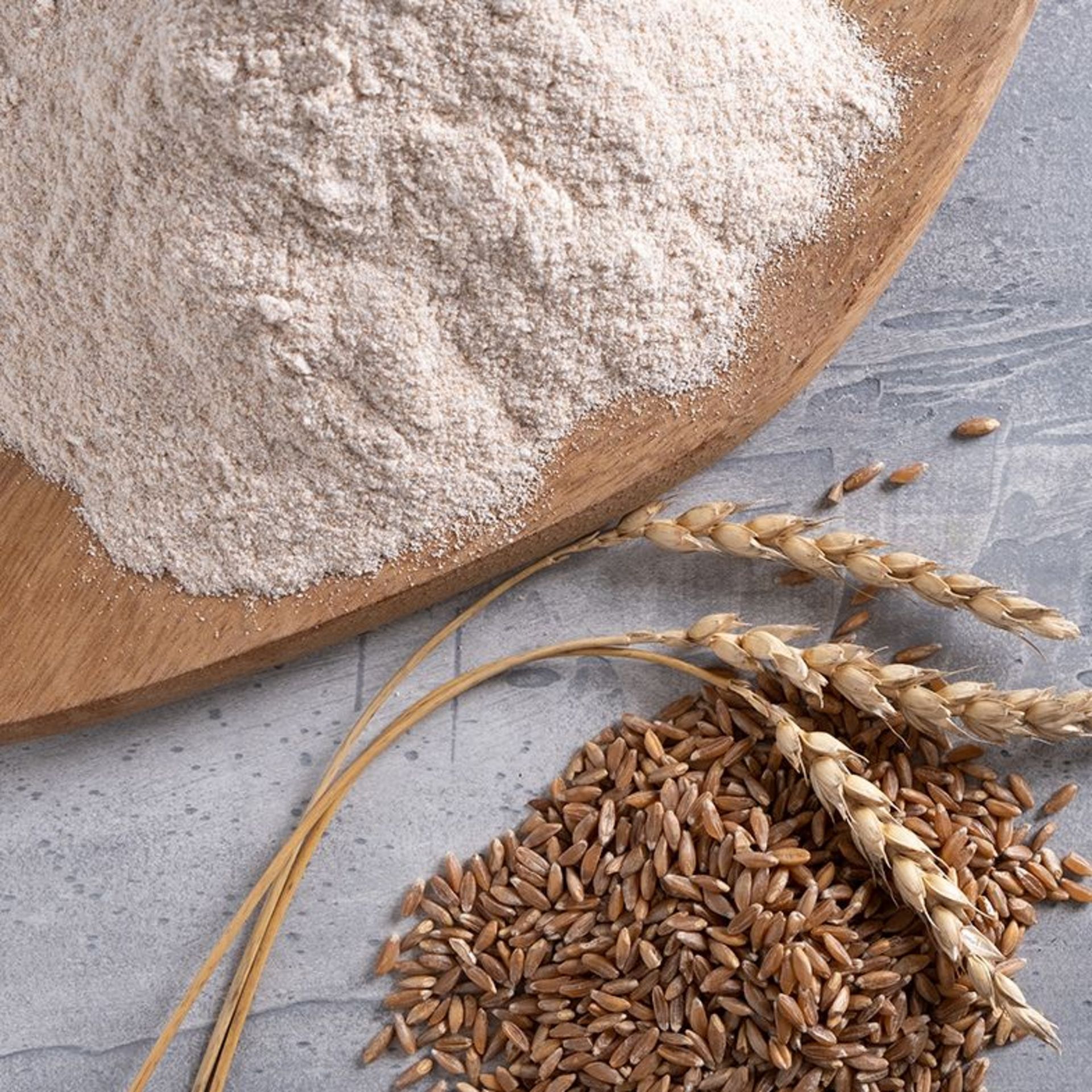 Dinkelkörner und Dinkelmehl auf einem Holzbrett Dinkelkörner und Dinkelmehl auf einem Holzbrett