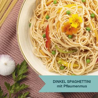 DINKEL MAX Spaghetti Pfanne mit Pflaumenmus, angerichtet mit Spaghetti, Pflaumenmus und einer essbaren Blüte als Garnitur