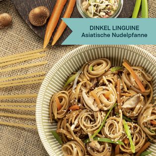Schüssel mit Dinkel Linguine und asiatischer Nudelpfanne, garniert mit Frühlingszwiebeln und Sesam